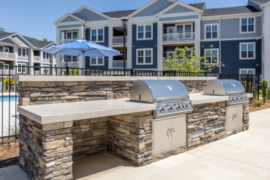 Outdoor grilling station at modern apartment complex pool