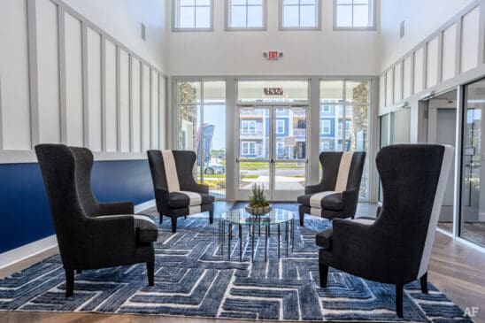 Modern apartment lobby seating area with armchairs and table