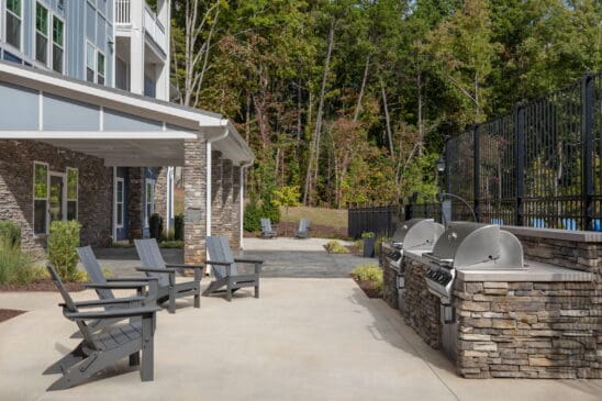 Apartment patio with grills and Adirondack chairs