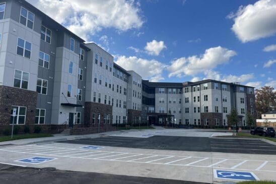 Modern apartment building with parking lot and blue sky