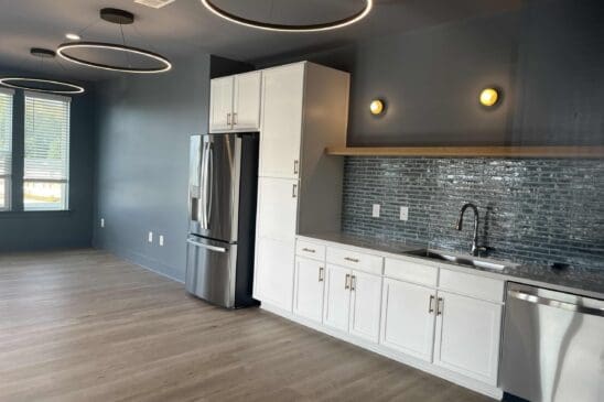 Modern kitchen with white cabinets and ring lights