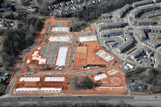 Aerial view of residential construction site and apartments